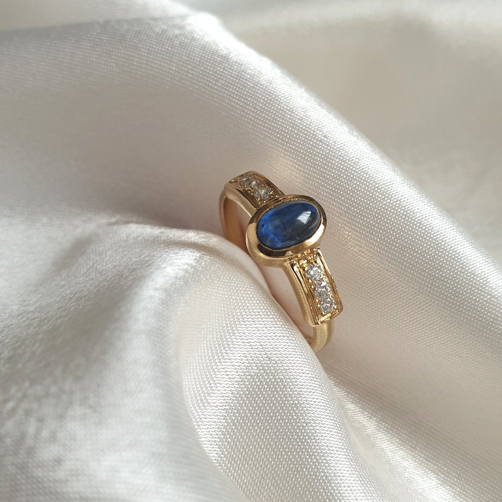 Anillo Serafina de oro con un zafiro en cabujón y diamantes.