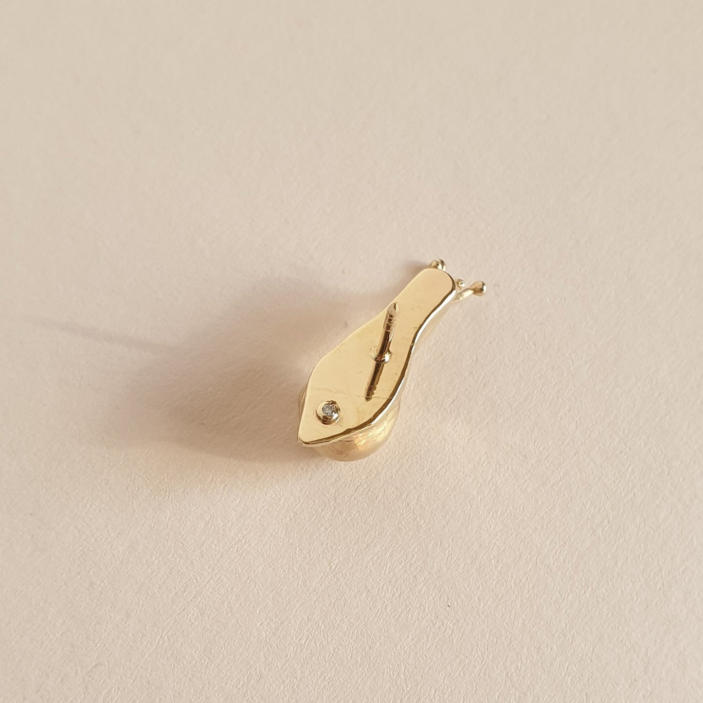 Detalle de reverso del pin caracol, donde se aprecia su diamante engastado.