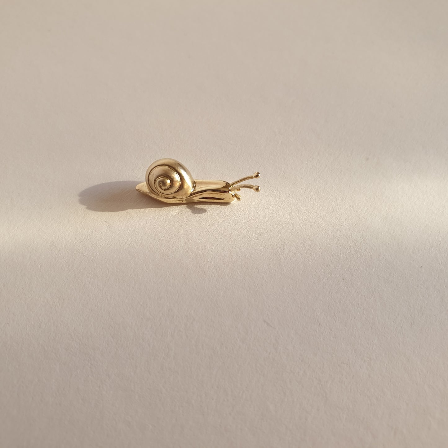 Pin caracol, fabricado artesanalmente en oro de 9k.