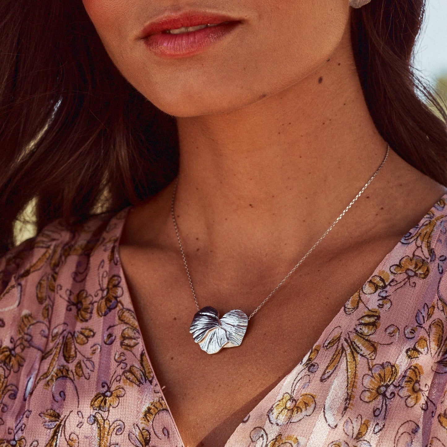 Mujer con collar orchid, con la forma de los pétalos de una orquídea.