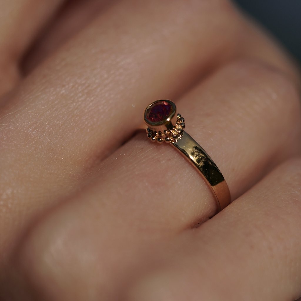 Anillo Ginebra fabricado por LA MUSA con oro y un granate natural.