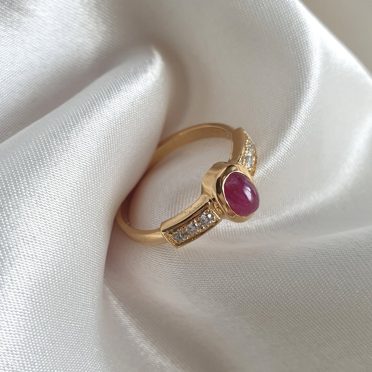 Anillo Serafina de oro con rubí en cabujón flanqueado por diamantes.