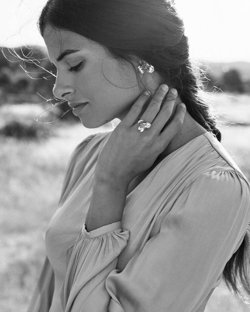 Mujer de perfil luciendo con elegancia los pendientes y anillo Floralis.