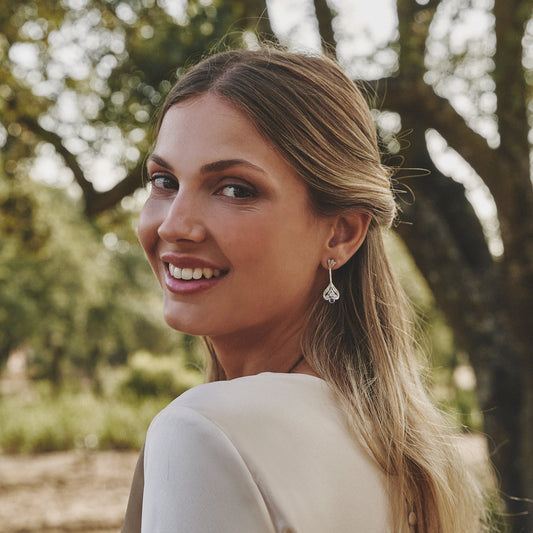 Mujer sonriente con los pendientes de novia Charlotte.