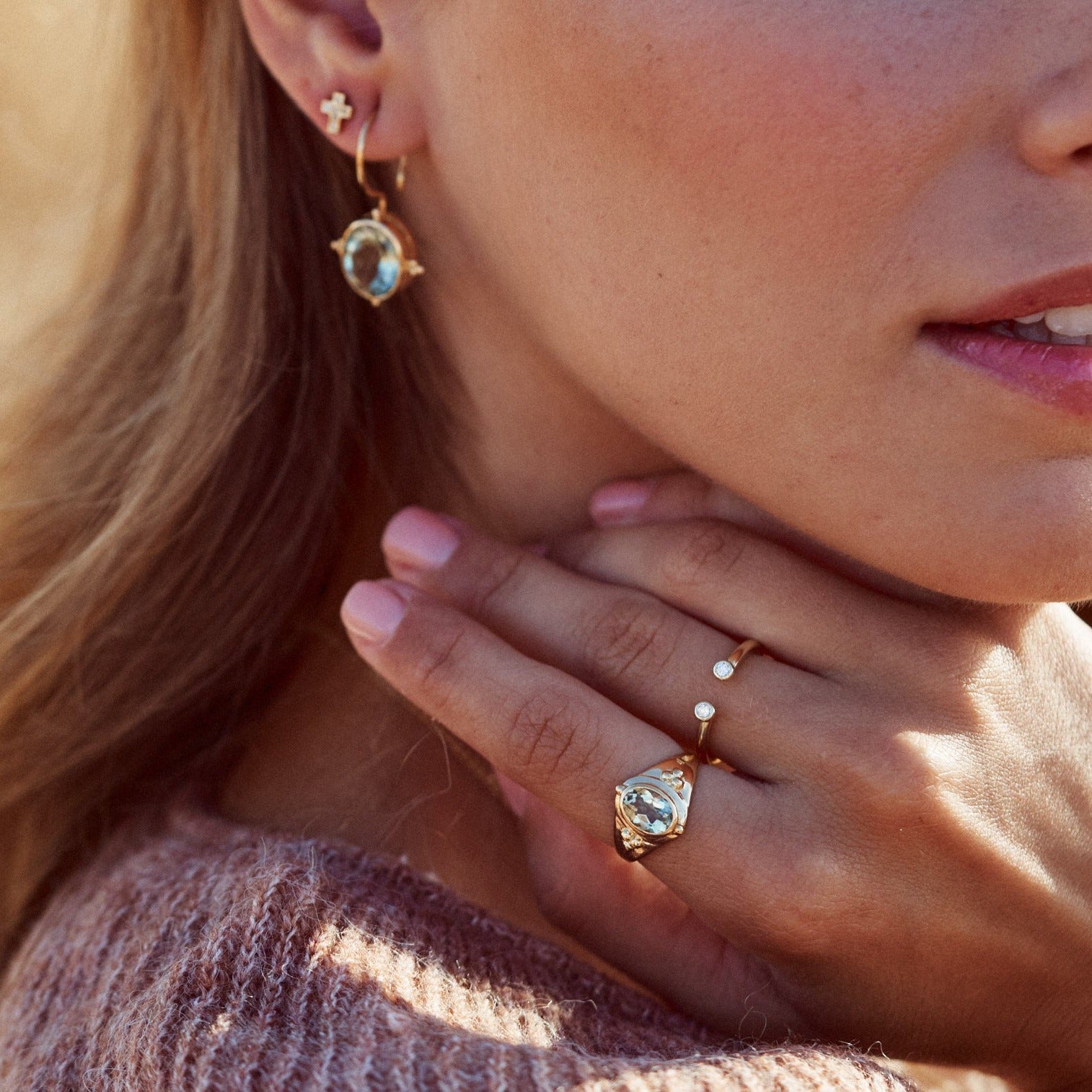 Mujer con la mano apyada en el cuello mostrando el Anillo Ophelia, elaborado con oro Farimined de 18k  y una prasiolita natural.