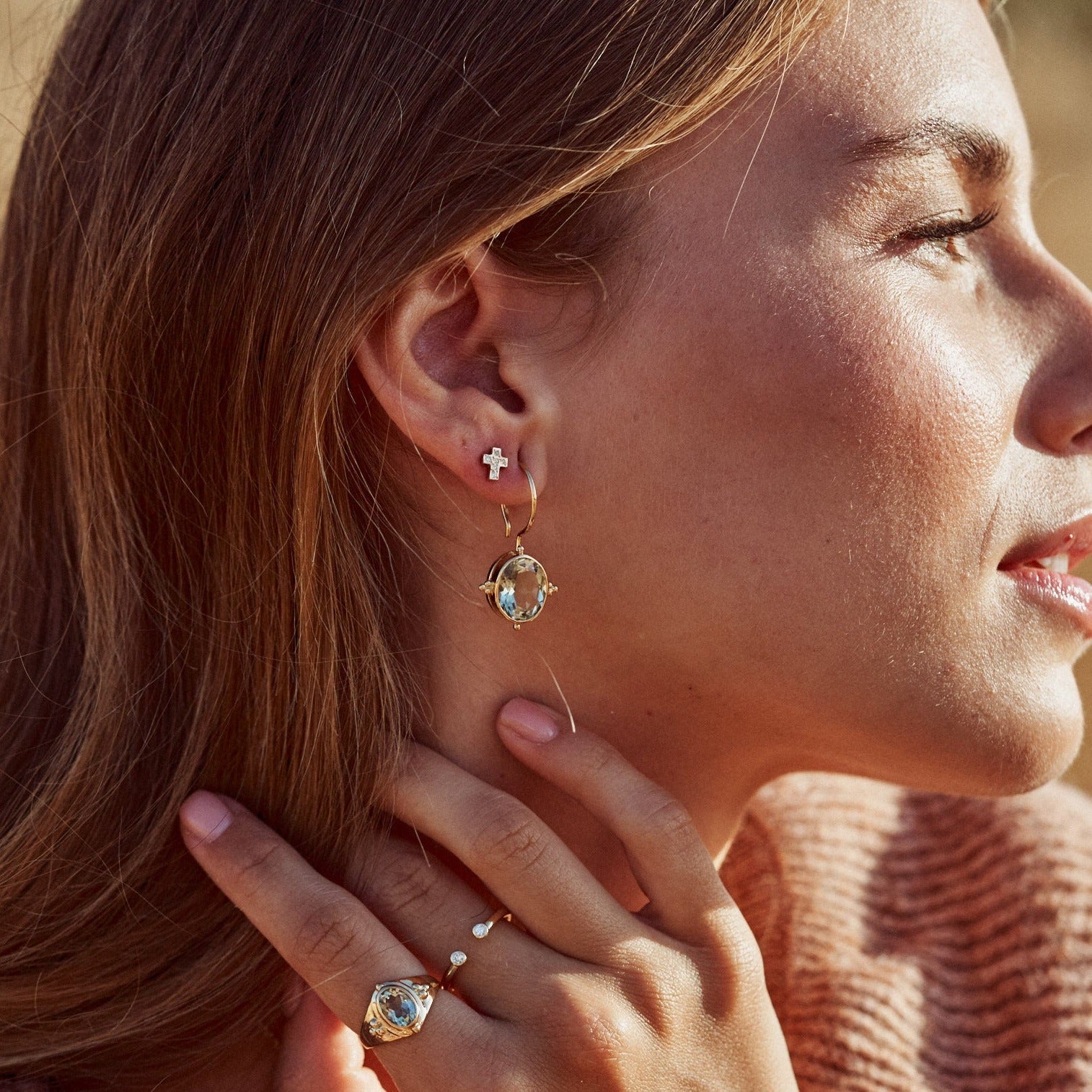 Perflil de modelo con los Pendientes Ophelia. Muestra su bonita forma ovalada y su estructura en oro de 18k con tres preciosas bolitas decorativas del mismo metal.