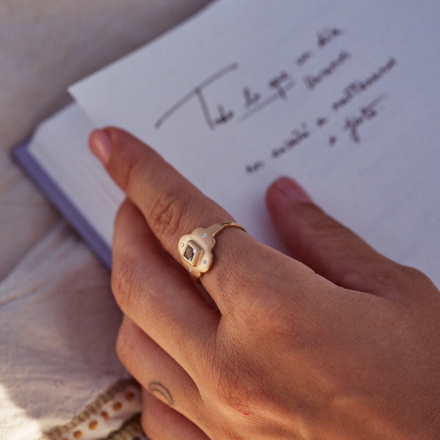 Detalle del dedo de una mujer con el Anillo Isolda,  en oro Farimined de 18k y con una aguamarina y cuatro diamantes..
