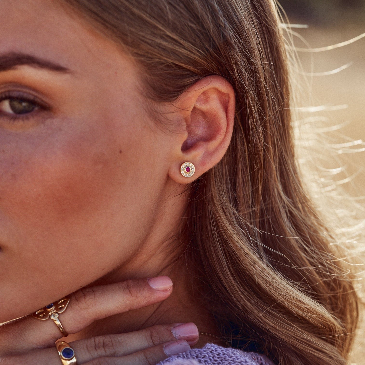 Foto de la oreja de la modelo con uno de los Pendientes Marie, donde se aprecia el precioso contraste del rubí y los diamantes con el oro y la piel.