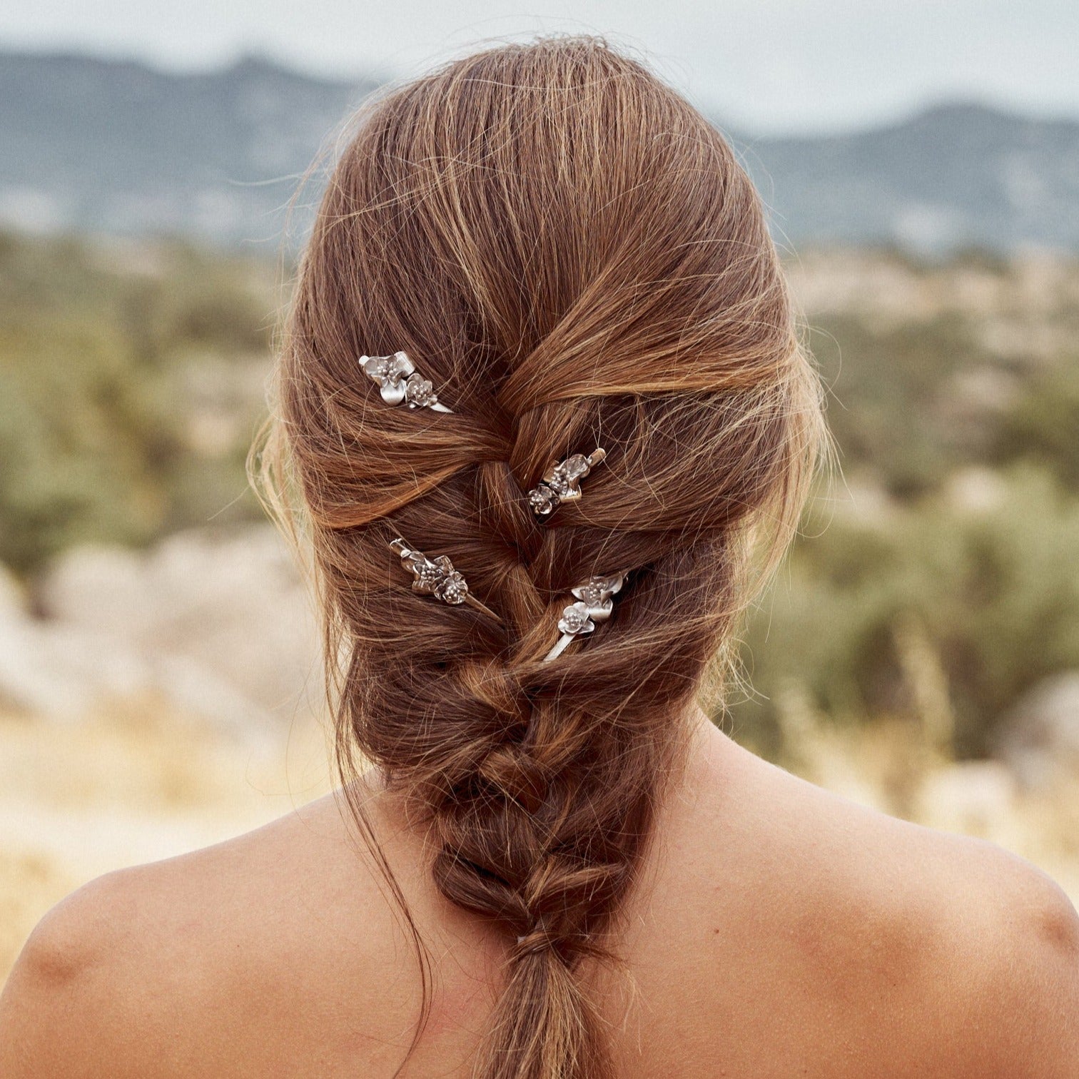Modelo mostrando su peinado con los pasadores Flora, accesorio para adornar el cabello con forma de flores, realizado a mano con plata de ley.