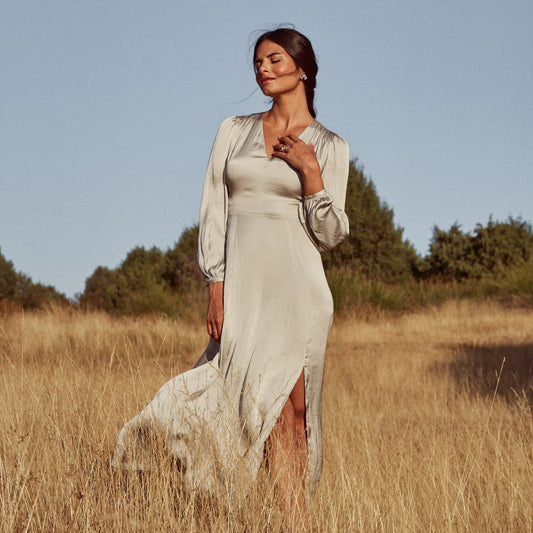 Mujer posando en un campo de espigas con el anillo y pendientes Floralis de plata de ley.