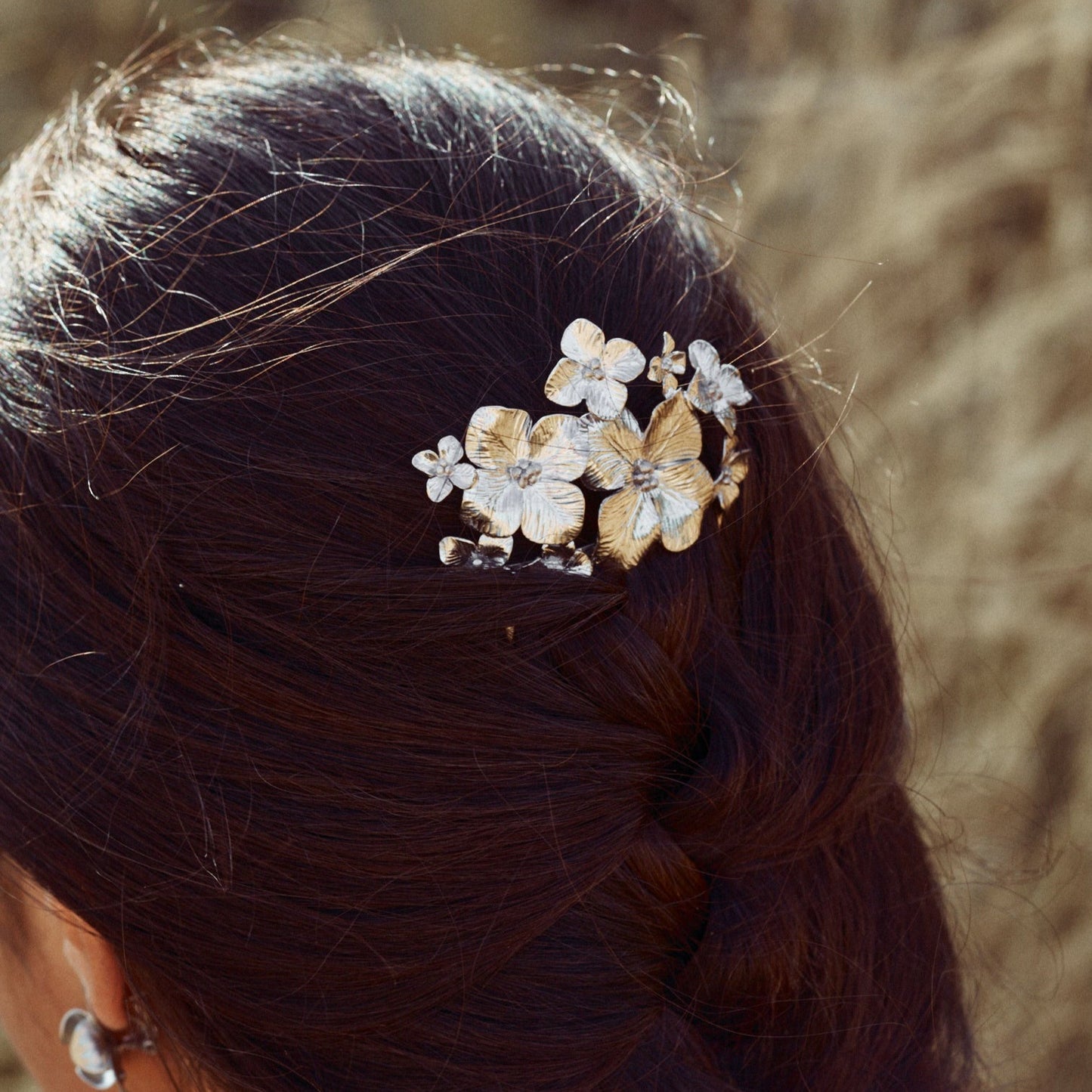 PEinado de la modelo decorado con la Peineta Bouquet, con preciosas flores de distintos tamaños, elaboradas con plata de ley.