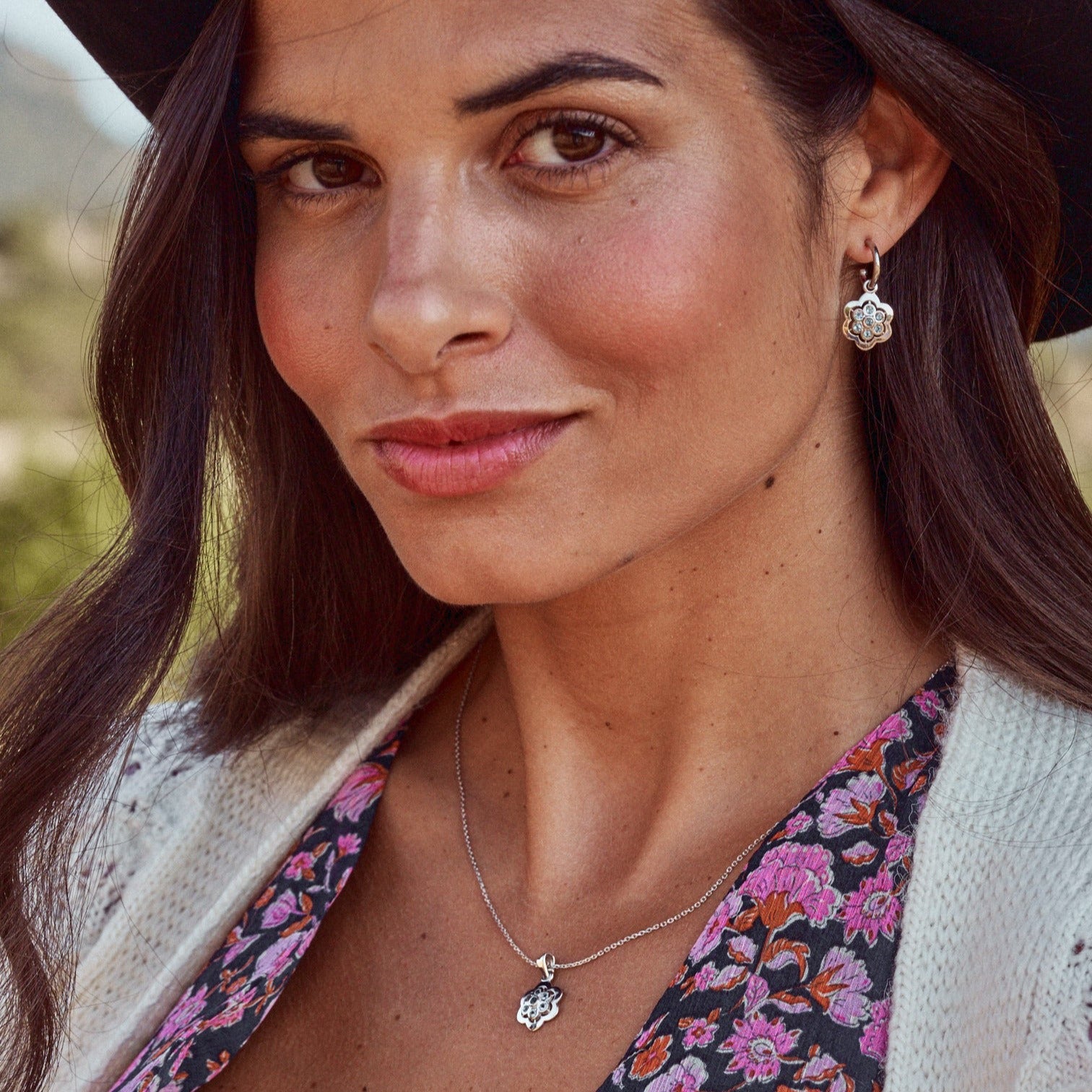 Mujer sonriente con colgante Delphine y pendientes a juego,